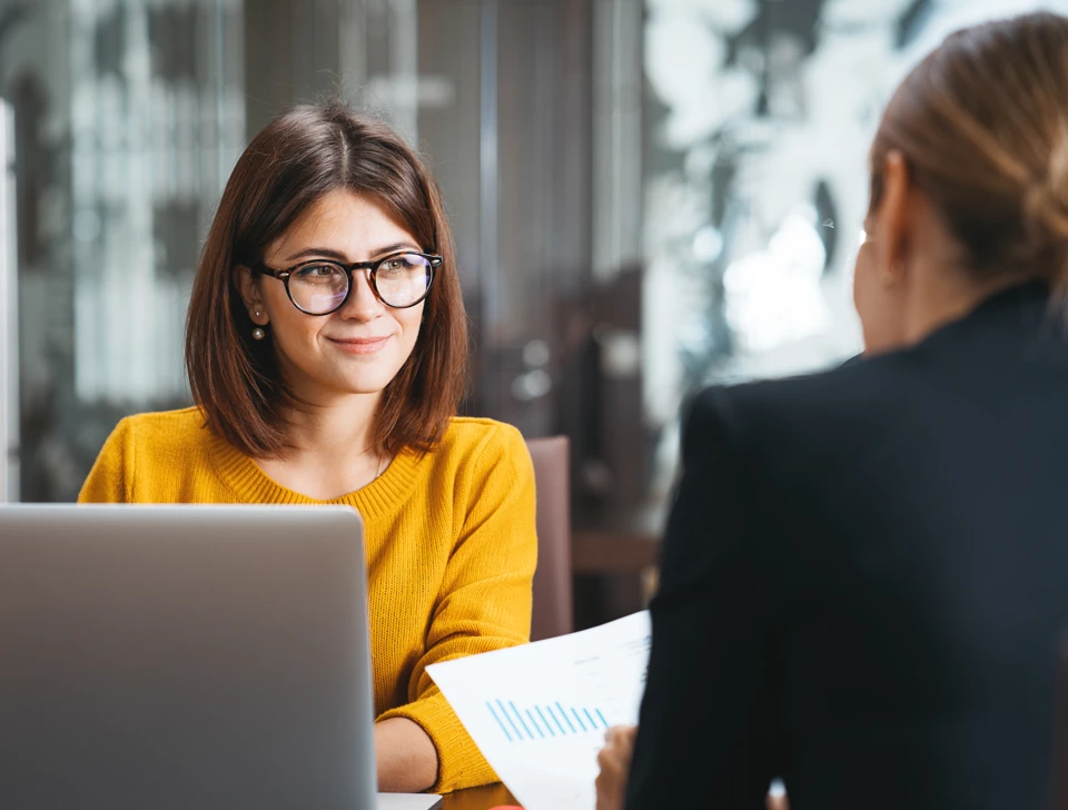 A woman on her laptop talking to a professional.