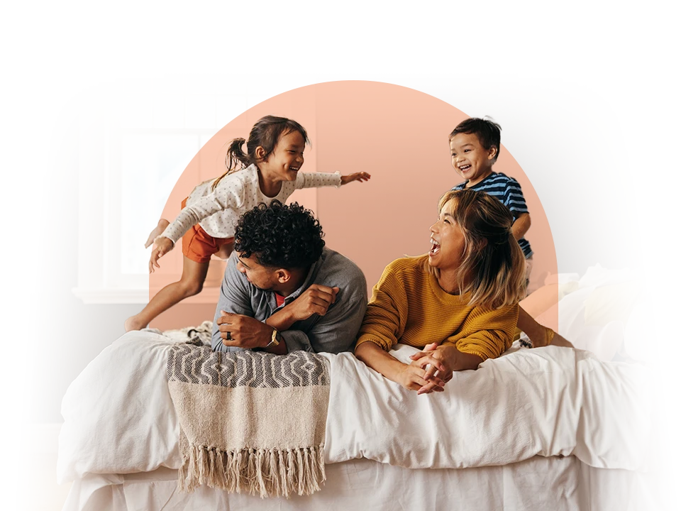 A family playing on a bed.